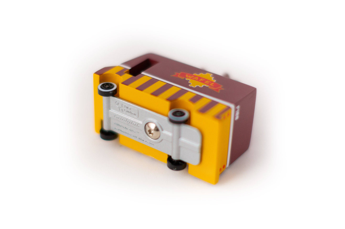 Small mechanical device with a yellow and red design on a white background