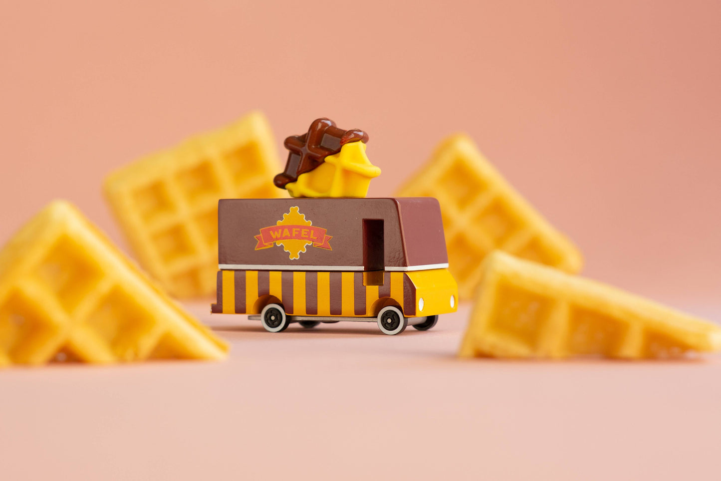 Toy waffle truck with waffles on a pink background